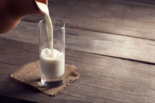 Glas-Milch-auf-altem-Holztisch