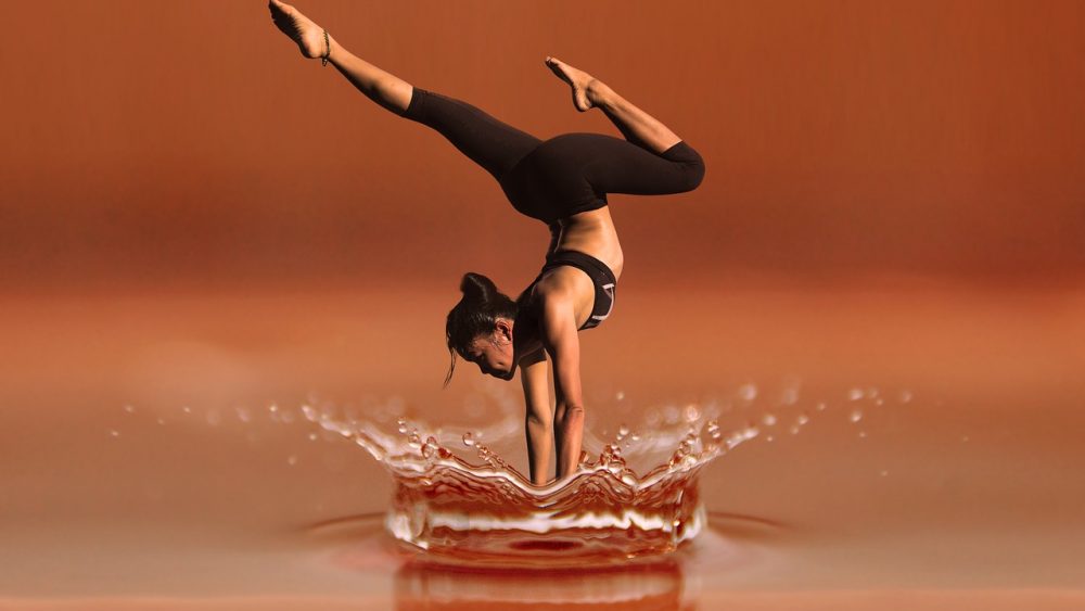 Frau-macht-Handstand-in-Wasserpfuetze