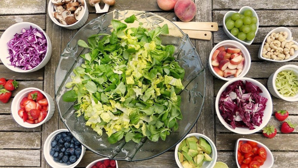 Gruener-Salat-umgeben-von-Obst-und-Gemuese